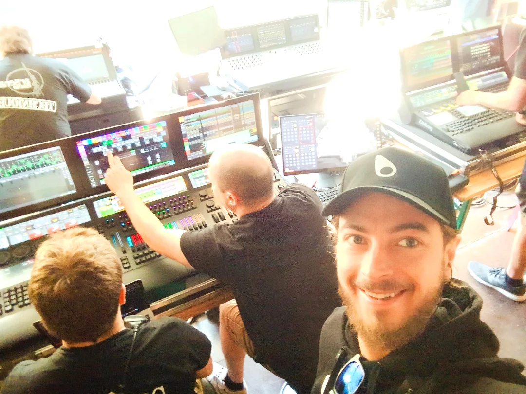 Andreas smiling near an audio control team and their mixing consoles