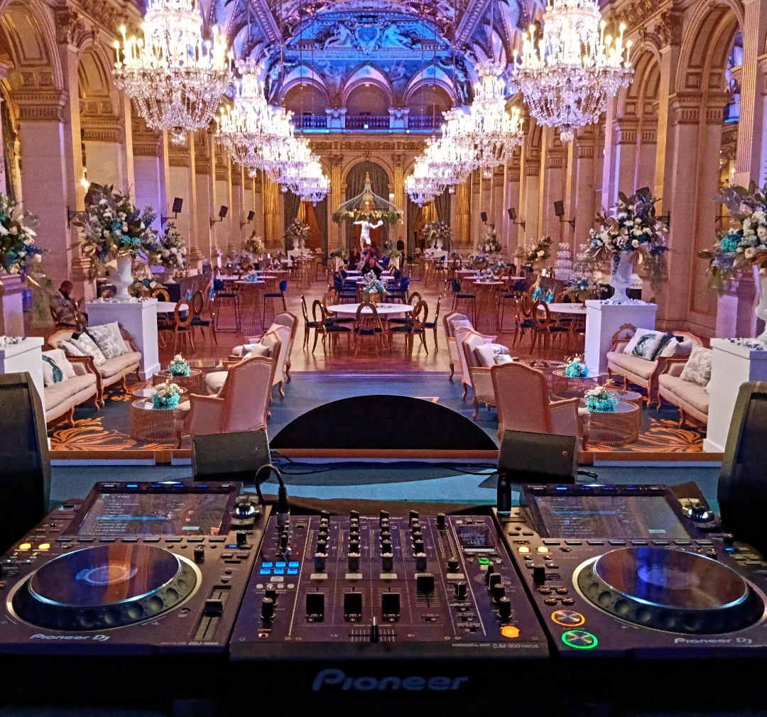 DJ equipment overlooking a chandelier-lit room at Paris City Hall